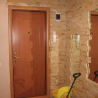 Photo of the entrance hall of a city apartment with stone wall decoration