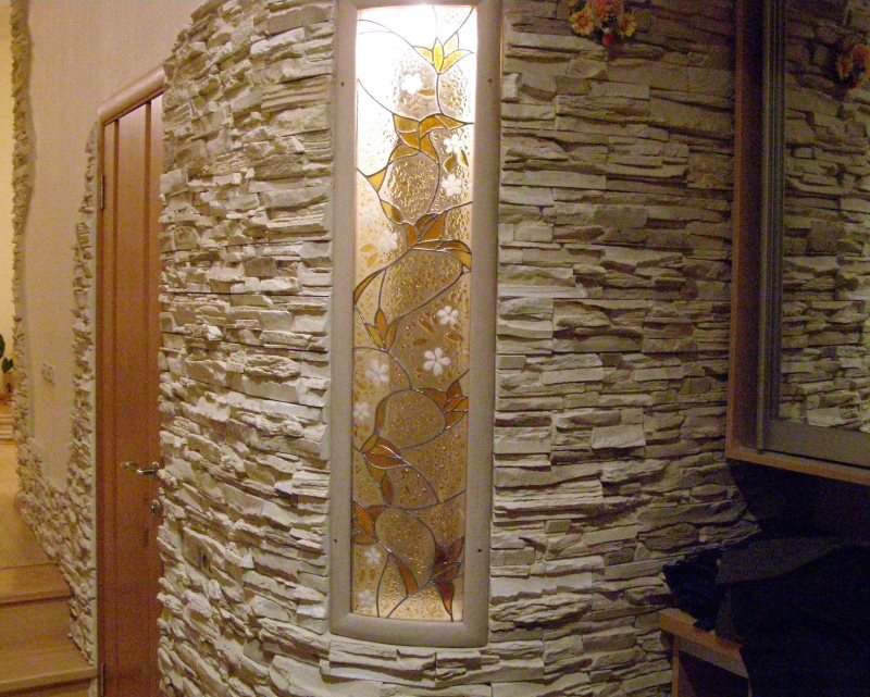 Stained glass window and decorative stone in the design of the hallway wall