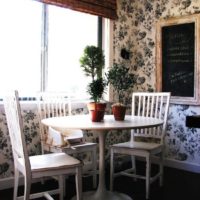 White dining table with living plants in the kitchen of a city apartment