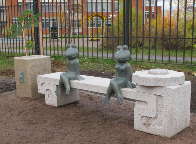 Figures of frogs sitting on a decorative bench