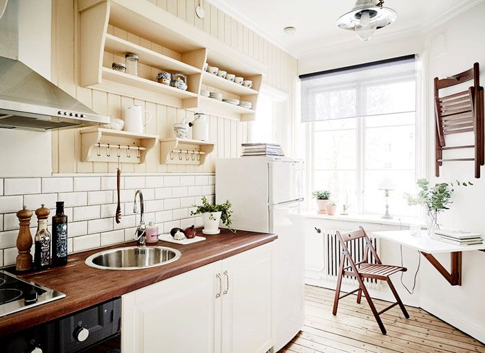 Une petite table pliante sur le mur d'une cuisine étroite