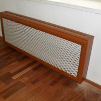 Écran maillé avec un boîtier en bois sur la batterie de chauffage